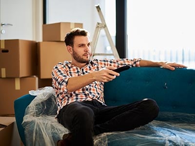 Man sitting on couch after moving apartments
