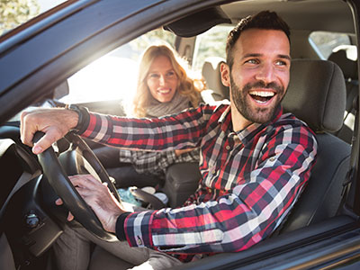 Man and woman smiling in car