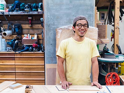 Man in yellow shirt measuring machinery
