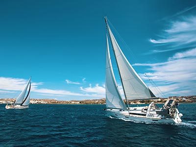 Two sailboats in the water with a blue sky